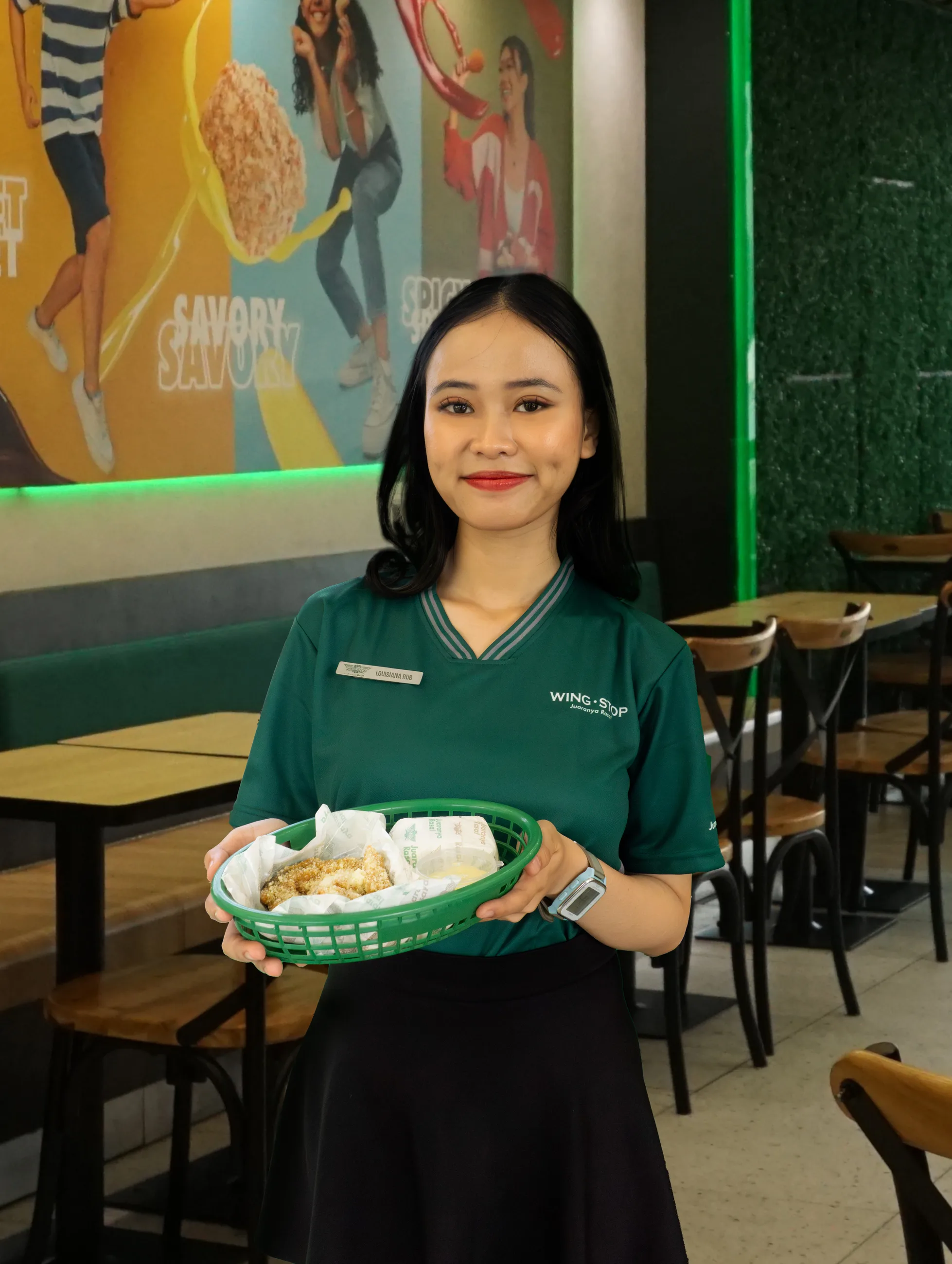 Kru Wingstop Indonesia bekerja sama melayani pelanggan di meja kasir